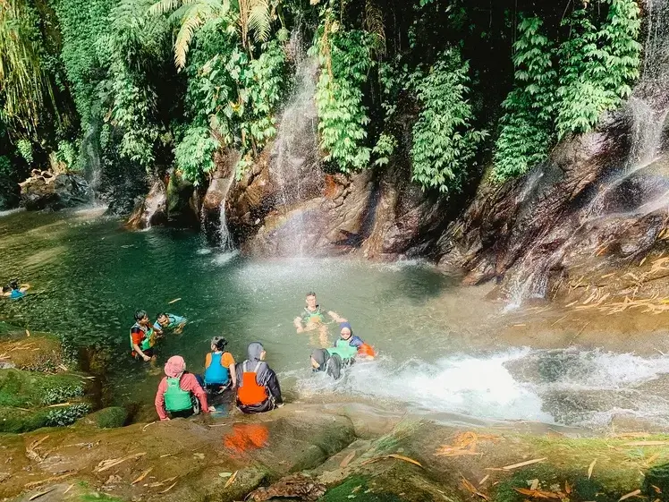 Visitors enjoying swimming in the river at Bhumi Bambu