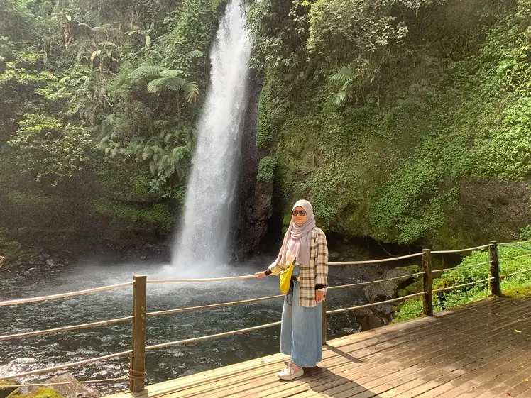 Curug Sawer waterfall surrounded by lush forest in Sukabumi